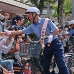自転車にまたがり町民らと交流するアキナの山名文和さん（左）と秋山賢太さん