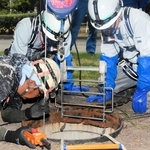 尼崎市の下水道管を調査する作業員ら。内部の水深が増して作業は中断となった＝２５日午後、尼崎市東松島町
