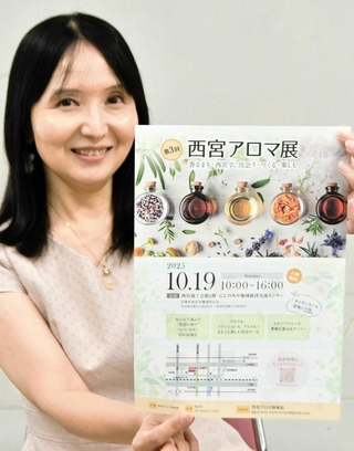１９日に開催する西宮アロマ展のチラシを手にする松本真規子さん＝西宮市和上町