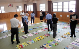 審査会で作品を選ぶ審査員ら＝尼崎北署（提供）