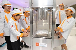 改装されたコーナーで冷凍食品作りを体験する子どもたち＝西宮市甲子園八番町