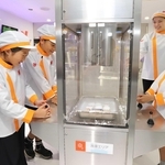 改装されたコーナーで冷凍食品作りを体験する子どもたち＝西宮市甲子園八番町