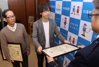 感謝状を受け取った家電量販店販売員の田島篤さん（中央）と千種ケ丘自治会の樋口保成会長（左端）＝宝塚市旭町１