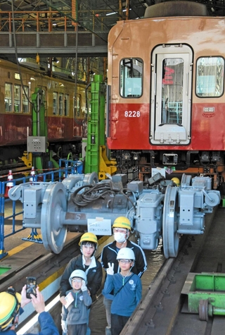 車両工場のピット見学を楽しむ親子連れ＝尼崎市北城内