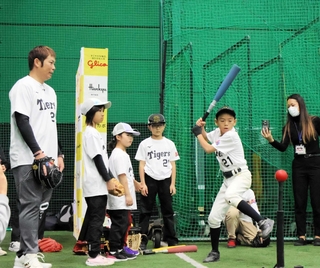 岩田稔さんからアドバイスを受けて打撃に取り組む参加者＝西宮市甲子園町