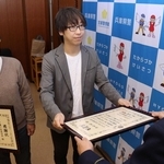 感謝状を受け取った家電量販店販売員の田島篤さん（中央）と千種ケ丘自治会の樋口保成会長（左端）＝宝塚市旭町１