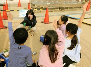 苗の植え方を児童たちに教える学生＝西宮市笠屋町
