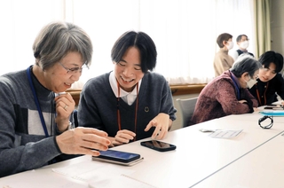 横並びに座り、一対一で丁寧にスマートフォンの使い方を教えるスマホカフェ＝芦屋市茶屋之町