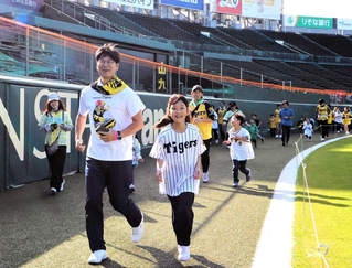 甲子園のグラウンドを走る親子連れら＝西宮市甲子園町