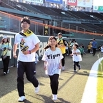 甲子園のグラウンドを走る親子連れら＝西宮市甲子園町