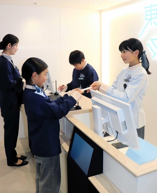 制服を着てホテルのフロント業務を体験する子どもら＝西宮市甲子園八番町