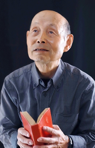 ぼろぼろにすり切れた日漢辞典を持つ箟和雄さん＝尼崎市内（撮影・小林良多）