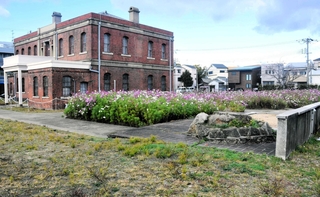 国の近代化産業遺産「ユニチカ記念館」。コスモスが咲く敷地西側に庭園が整備される＝尼崎市東本町１