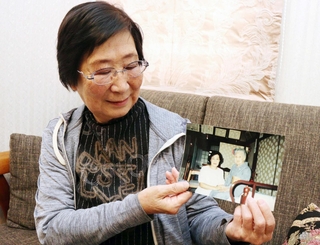 写真に写る叔母の高橋普子さん（左）を見つめる金子一恵さん＝西宮市甲子園浦風町