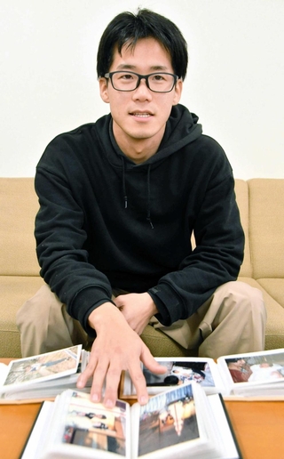 母多永子さんの写真を見ながら振り返る井上貴行さん＝明石市内