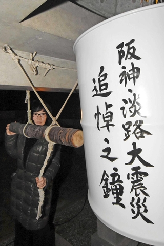 震災の記憶を語り継ぐために設けられたドラム缶の鐘を突く参列者＝１７日午前５時５５分、西法寺