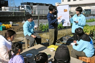 芋煮会で母国の里芋料理を紹介する関西国際大の中国人留学生＝尼崎市田能６