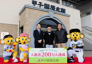 入館２００万人目となった田浦大翔さん（中央）と淳一さん（右）親子＝西宮市甲子園町