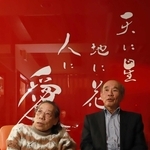 三和之家を経営する田山華栄会長（左）と夫の幸雄社長。施設の真っ赤な壁には大切にする言葉が記されている＝尼崎市内（撮影・小林良多）