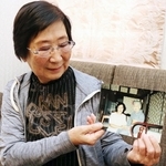 写真に写る叔母の高橋普子さん（左）を見つめる金子一恵さん＝西宮市甲子園浦風町