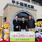 入館２００万人目となった田浦大翔さん（中央）と淳一さん（右）親子＝西宮市甲子園町