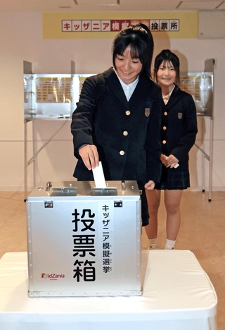 実際の投票箱を使って模擬投票をする小学生＝西宮市甲子園八番町