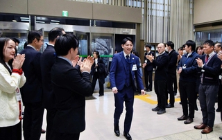 西宮市職員らに迎えられる甲斐野翼さん（中央）＝西宮市六湛寺町