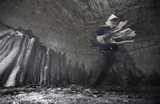 窯出しの際、中はまだ１００度近い場合も。灰だらけになって炭を運び出す＝川西市黒川