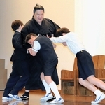 宇良関に押し相撲を挑む児童たち＝宝塚市武庫川町