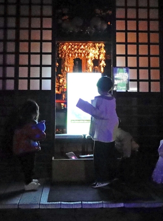 善通寺にはモニターを設置し、寺に伝わる「首なし地蔵」由来のアートを展示した＝尼崎市寺町