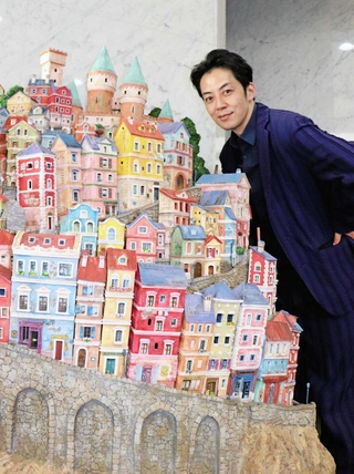 川西市役所１階に展示されているコマ撮り短編映画「ボトル・ジョージ」のオブジェと西野亮廣さん＝川西市中央町