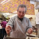 「秘伝のたれ」で煮込んだホルモンを混ぜる大城徳幸さん＝尼崎市玄番北之町