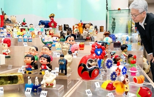 神戸新聞の連載コラムで紹介された貯金箱を集めた展示＝尼崎市西本町北通３