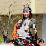 白馬にまたがり、沿道の観衆に手を振る巴御前役の奥西愛美さん＝川西市美園町