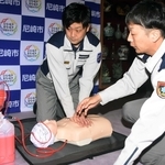 「めぐる君」を実演する尼崎市消防局の眞造務救急課長（右）と黒川貴紀消防士長＝市役所