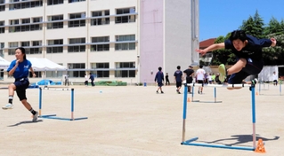 地域クラブの体験会でハードルの練習に励む生徒ら＝伊丹市鴻池３