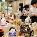 気になった貯金箱を取材する（左から）林莉香さん、西川悠さん、大川琉輝さん＝尼崎市西本町北通３