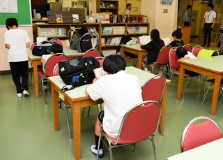 学校の開門まで図書室で本を読んで過ごす児童ら＝西宮市深津町