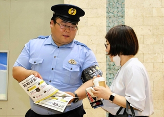 通行人に特殊詐欺の手口を説明して注意を促す西宮署員＝西宮市田中町