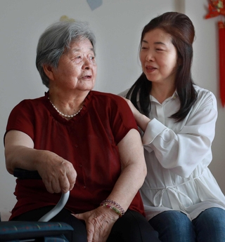 自宅で来し方を振り返る石原秀子さん（左）。五女の梨花さんが寄り添う＝宝塚市（撮影・小林良多）