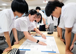 避難所運営ゲームで、図上の体育館に避難者のカードを配置する生徒たち＝宝塚市売布東の町