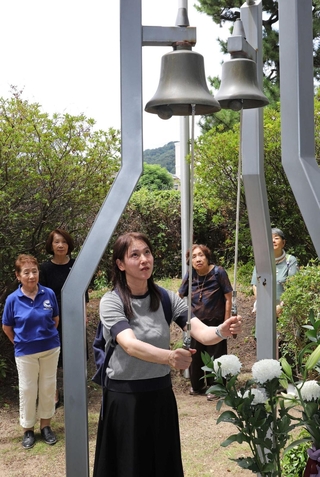正午のサイレンに合わせ、平和の鐘を鳴らす参加者＝芦屋市業平町