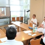 過去のつどいの写真を映し、活動を振り返る三井ハルコさん（右から３人目）ら＝川西市小花１