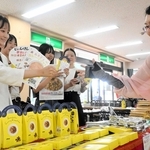 大学生は販売会に訪れた買い物客らに防災食をアピールし、じゃんけんで交流した＝尼崎市潮江１