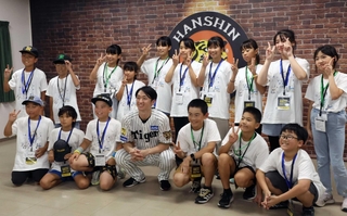 阪神タイガースの近本光司選手（中央）と記念撮影をする子どもたち＝西宮市甲子園町