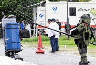 かばんに入っている爆発物を処理する県警機動隊員ら＝尼崎市扇町