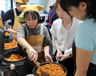 大学生と協力しながら調理に取り組む子どもたち＝西宮市田代町