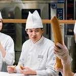 社員から説明を聞き、フランスパンを試食する学生ら＝西宮市甲子園八番町