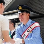 通行人に啓発グッズを手渡す福留孝介さん＝芦屋市大原町