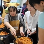大学生と協力しながら調理に取り組む子どもたち＝西宮市田代町